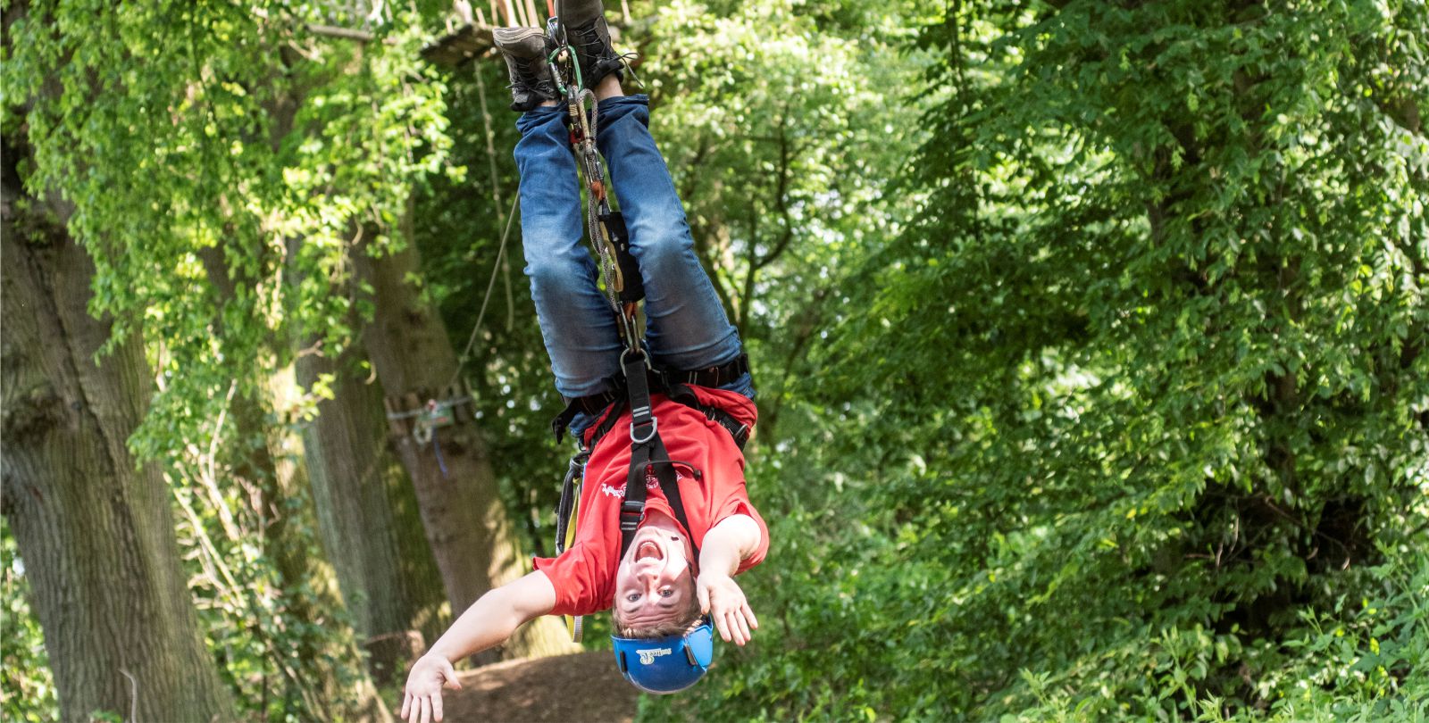 Junger Mann hngt kopfber in in der Schwebebahn