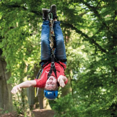 Junger Mann hngt lachend kopfber in seiner Klettersicherung