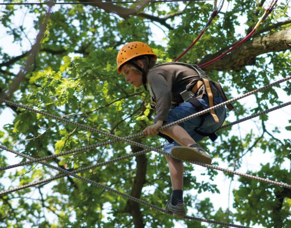 Ein Kind balanciert konzentriert auf zwei Seilen