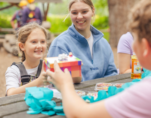 Ein Kind packt im Kletterpark Geschenke aus