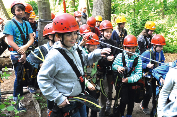Eine Gruppe von Kindern und Jugendlichen macht sich zum Klettern bereit
