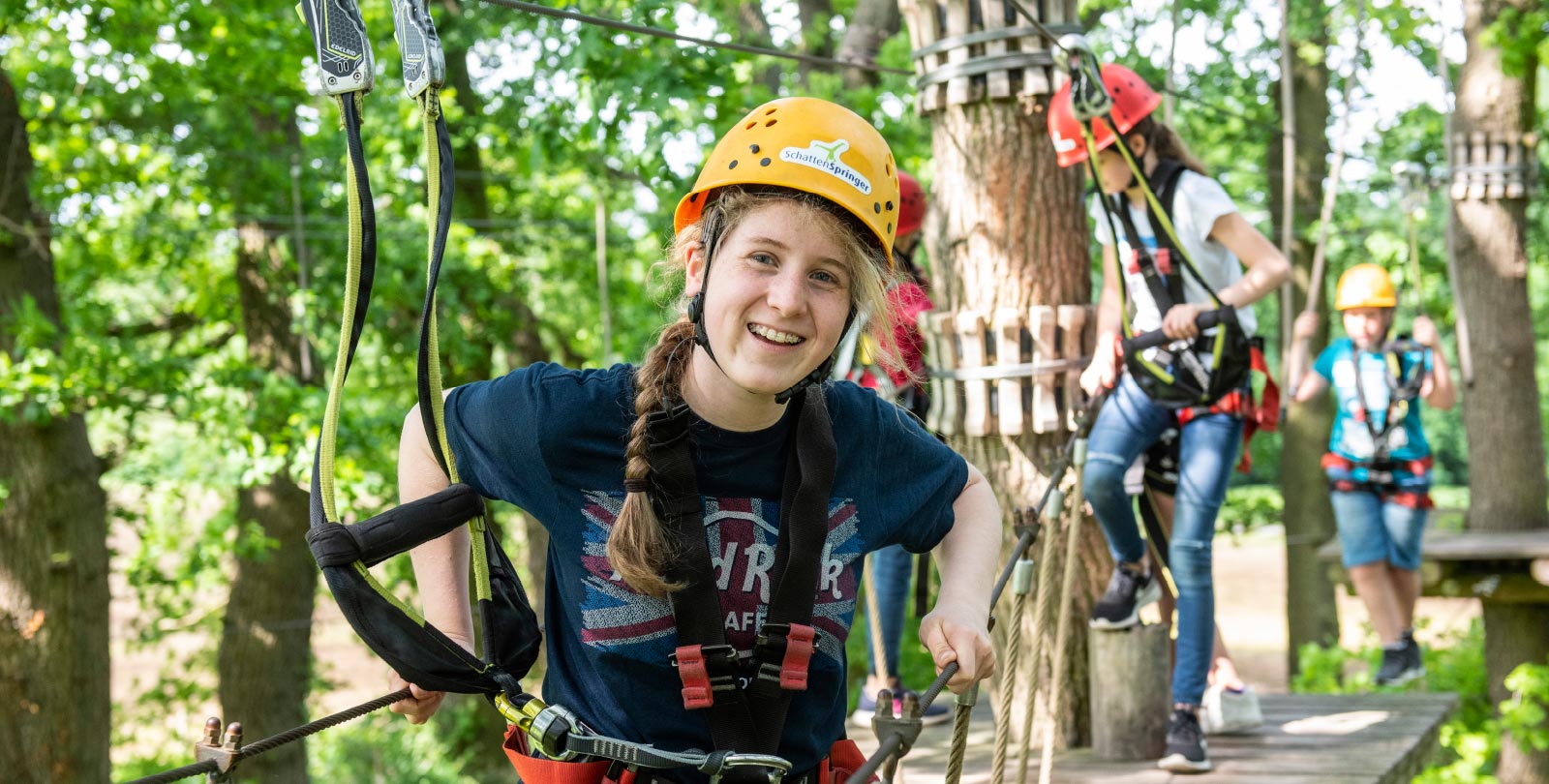 Junges Mdchen im Halbportrt mit Helm und Sicherung lchelt in die Kamera